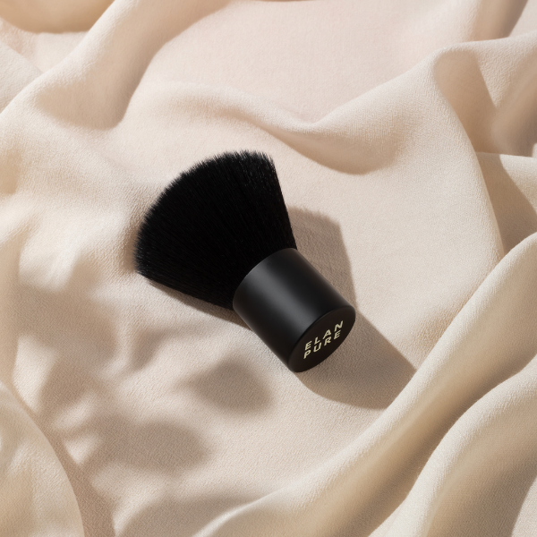 Beauty brush on a soft, draped fabric background