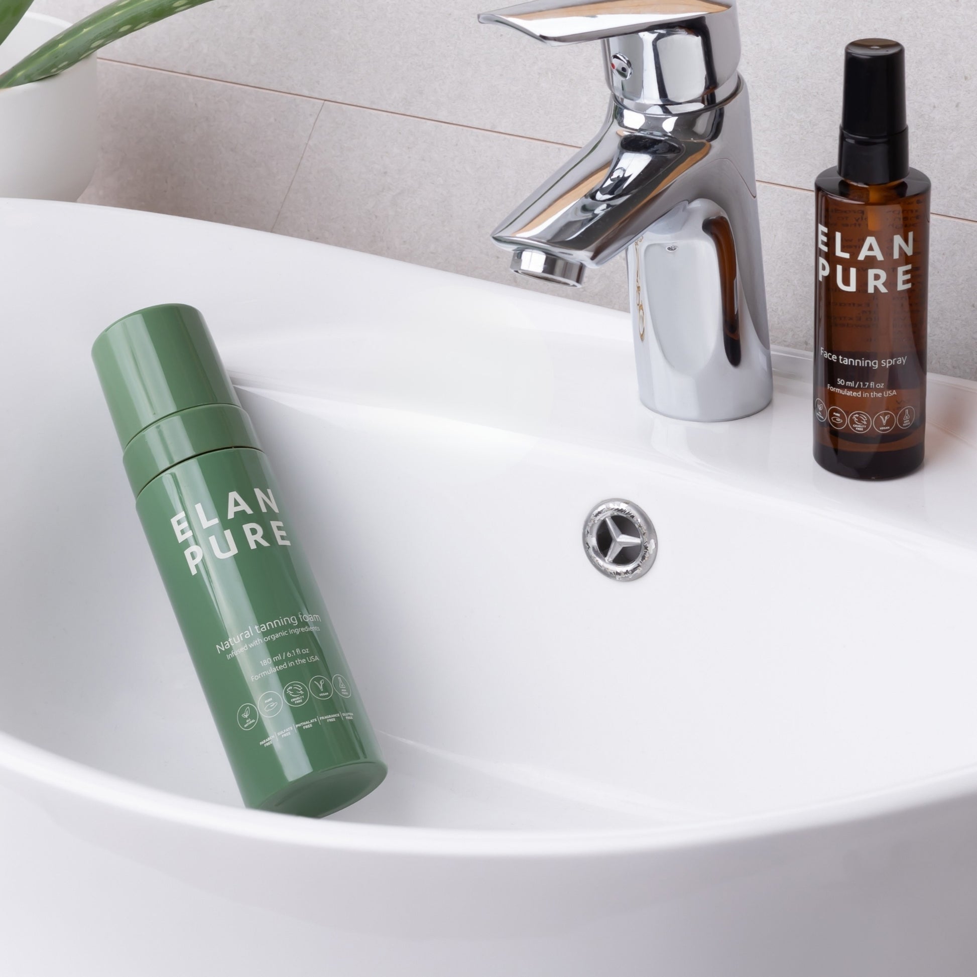Two ELAN PURE skincare products on a bathroom sink with a faucet in the background.